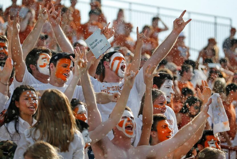 Longhorn fans in the stands enjoy the rain during pre-game warmups before the Notre Dame...