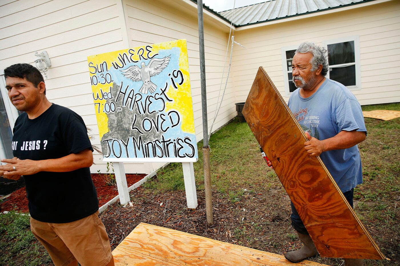 Joy Ministries pastor Joel Garcia (right) was removing the plywood panels from the church so...