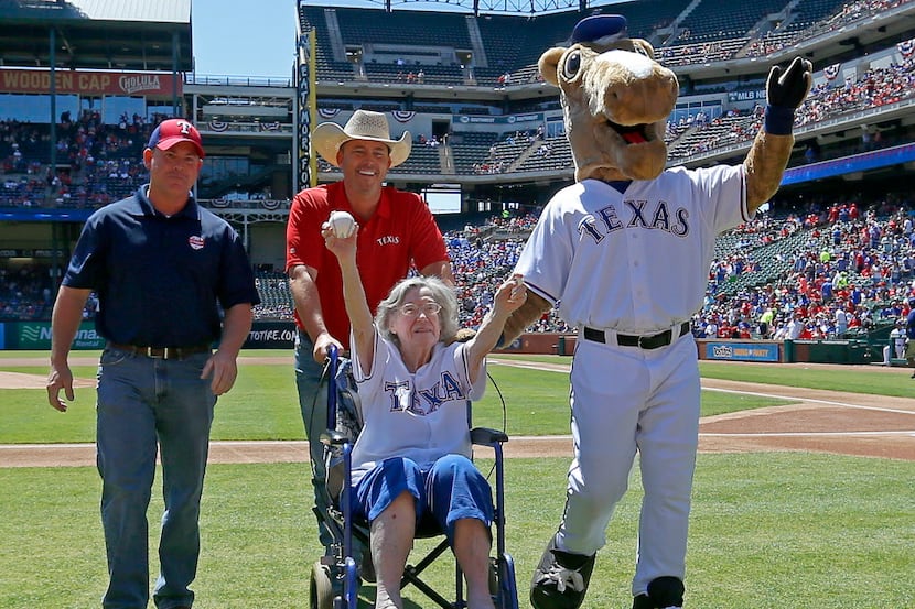 Elizabeth Sullivan of Fort Worth waves to the crowd as she wheels off with Kirk Conger, of...