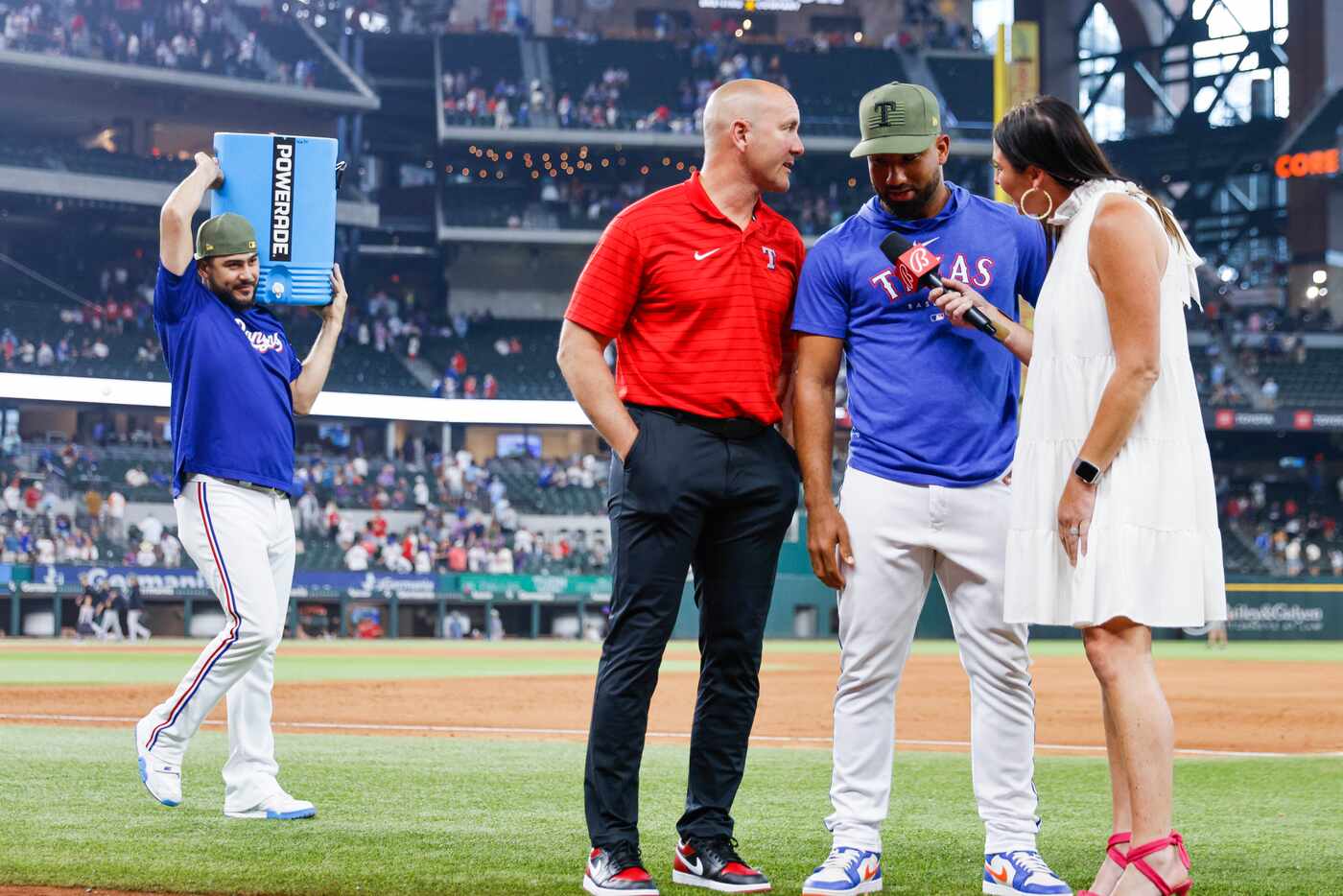 Texas Rangers starting pitcher Martin Perez (left) approaches with a water cooler towards...