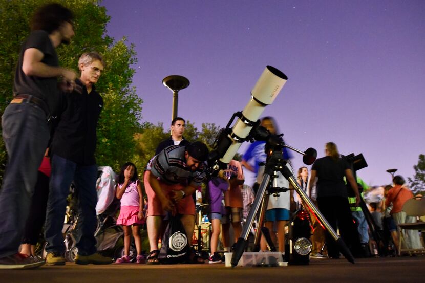 Felipe Cuellar, 36, of Dallas, views the planet Saturn through a telescope during a Mars...