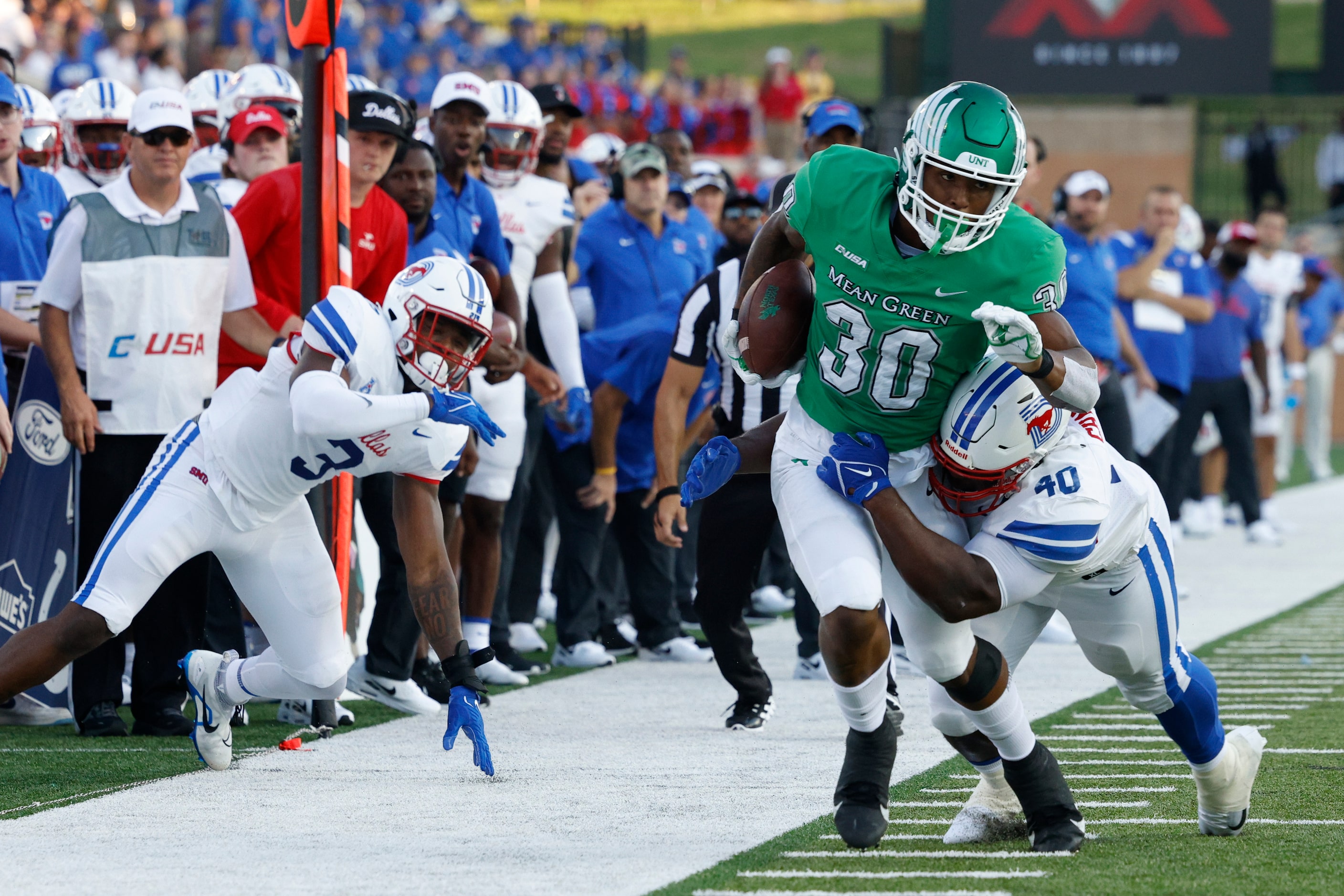 SMU defensive tackle Elijah Chatman (40) tackles UNT tight end Var'Keyes Gumms (30) during...