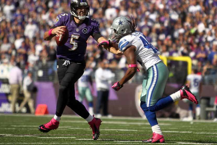 Baltimore Ravens quarterback Joe Flacco (5) is pressured by Dallas Cowboys strong safety...