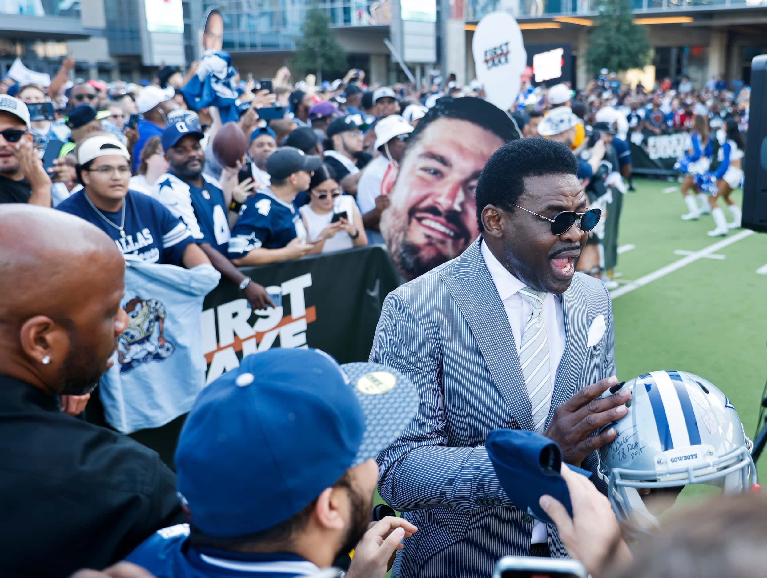 Former Dallas Cowboys player Michael Irvin hands out autographs during the recording of...