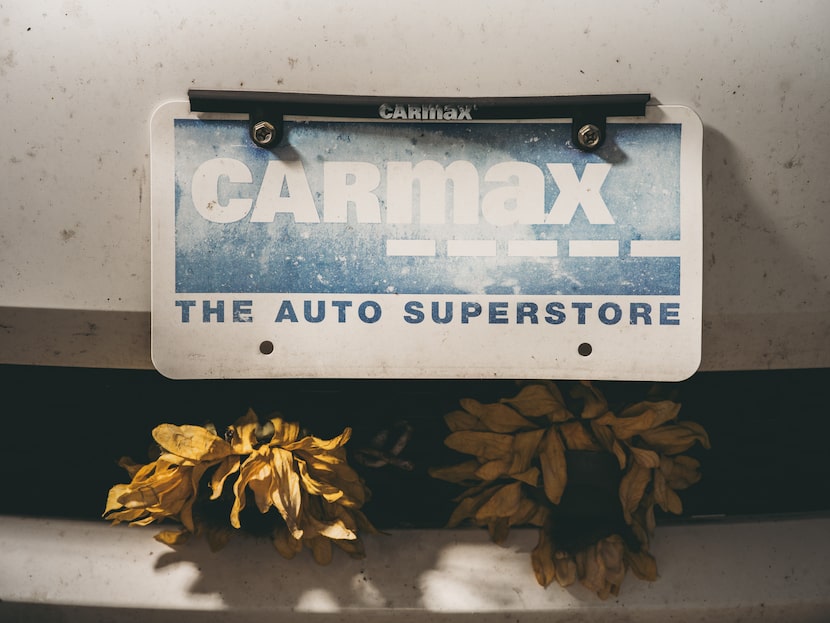 Caption: A faded Carmax plate on the front of Patterson s car.