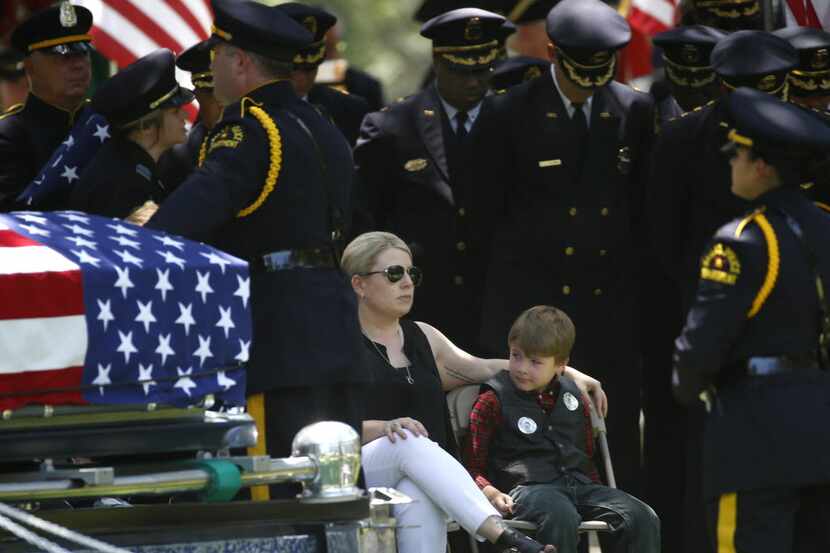 Katrina Ahrens, wife of fallen Dallas police officer Lorne Ahrens, sits with son Magnus...
