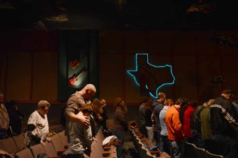
Members of The Gathering, a Mesquite-based church, bow their heads during a service at the...