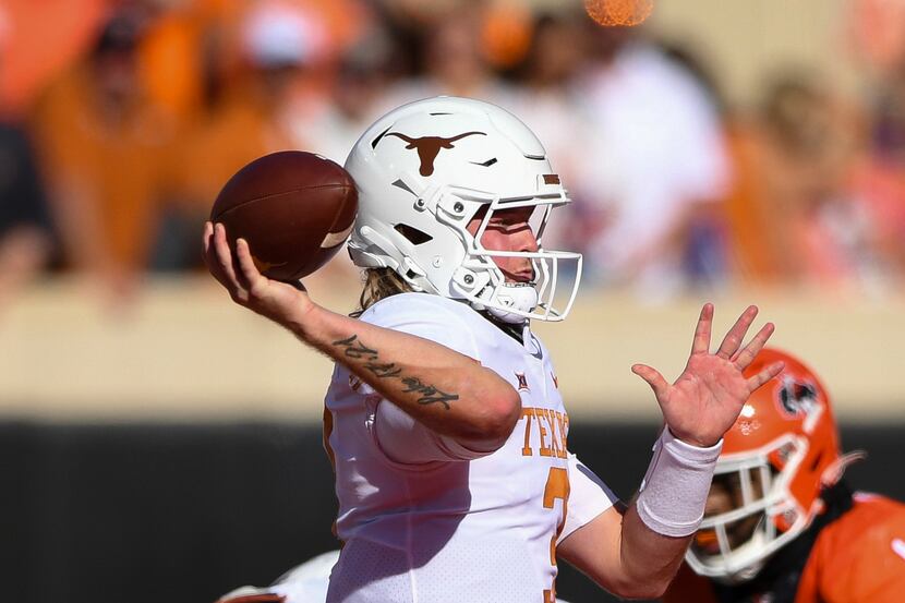 Texas quarterback Quinn Ewers, left, looks to throw a pass during the first half of an NCAA...