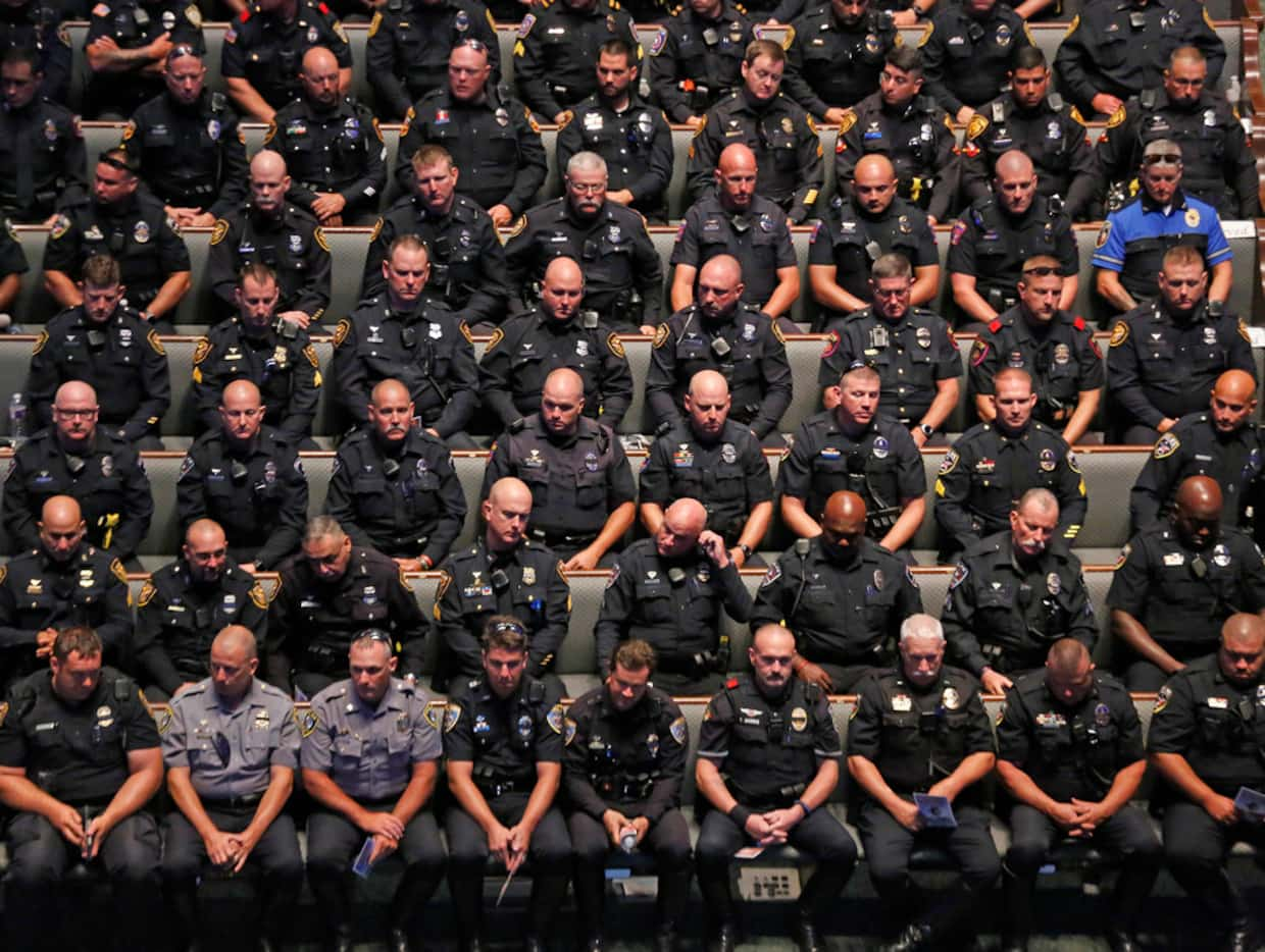 Law enforcement officers sat in the church as the pass by ceremony started at the funeral...