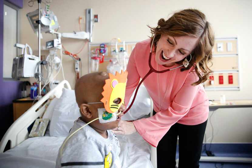 Dr. Tiffany Simms-Waldrip (right) laughs as patient Akshaj Nagilla roars through his lion...