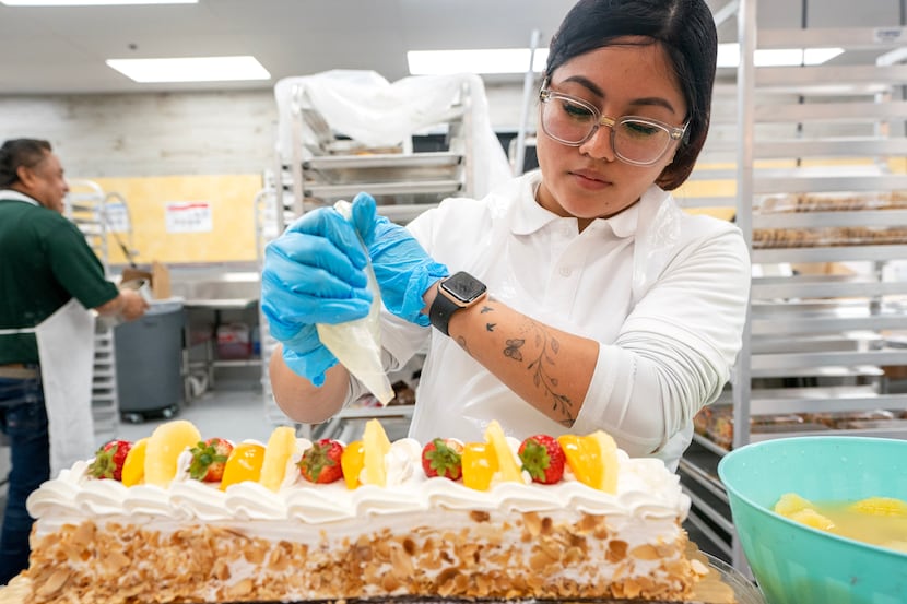 Claudia Lopez decorates a cake in the newest El Rio Grande Latin Market grocery store at...