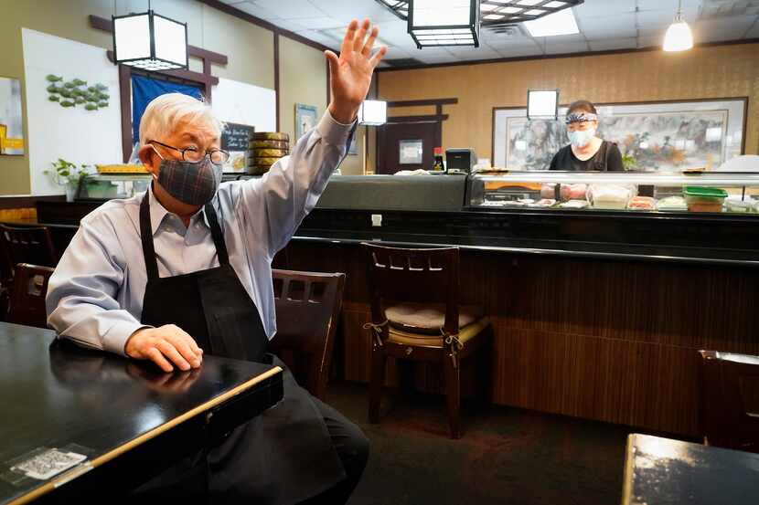 Sushiya restaurant owner Kang Lee waved to a departing customer as Junok Kim worked the...