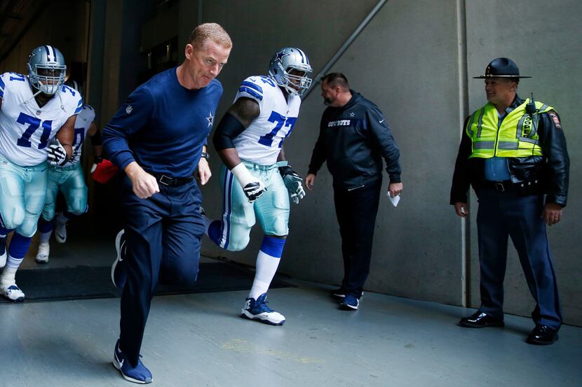 Dallas Cowboys head coach Jason Garrett and the Dallas Cowboys make their way on the field...