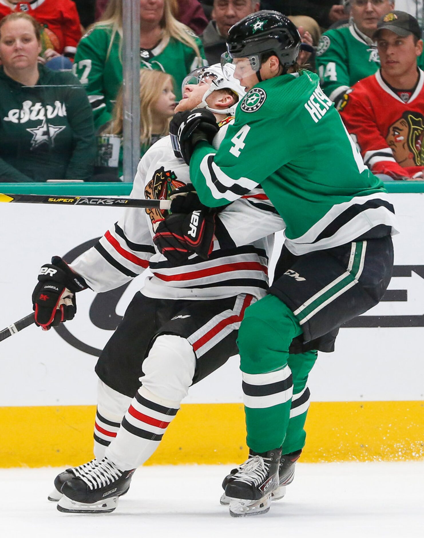 Dallas Stars defenseman Miro Heiskanen (4) and Chicago Blackhawks center Drake Caggiula (91)...