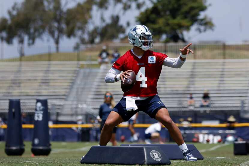 Dallas Cowboys quarterback Dak Prescott (4) points to his receiver as he negotiates the...