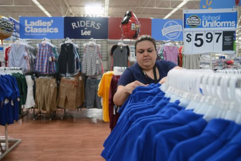 
Wal-Mart employee Nidia Flores arranges shirts ahead of the annual tax-free weekend in Texas.

