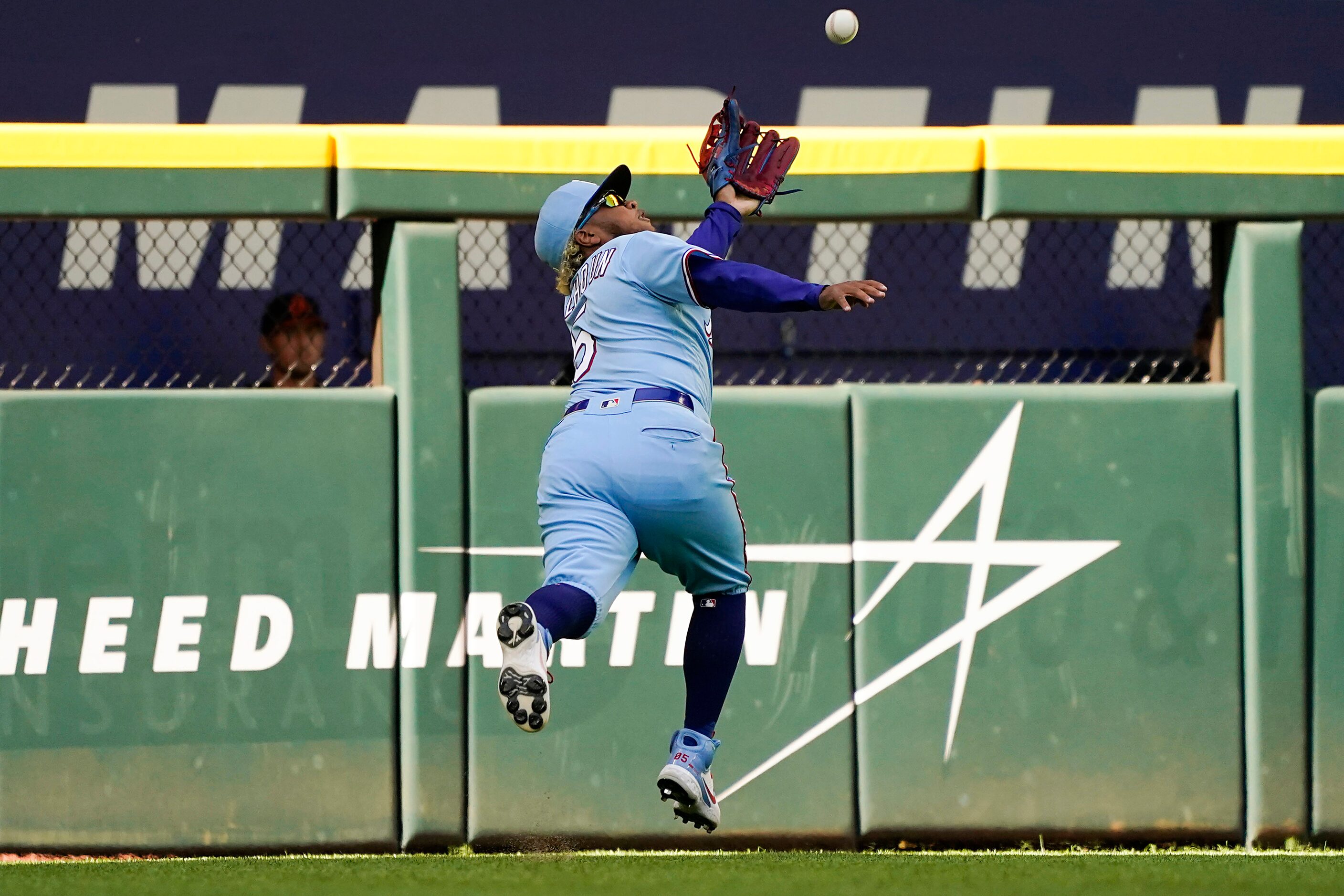 Texas Rangers left fielder Willie Calhoun makes a running catch on a line drive by Baltimore...