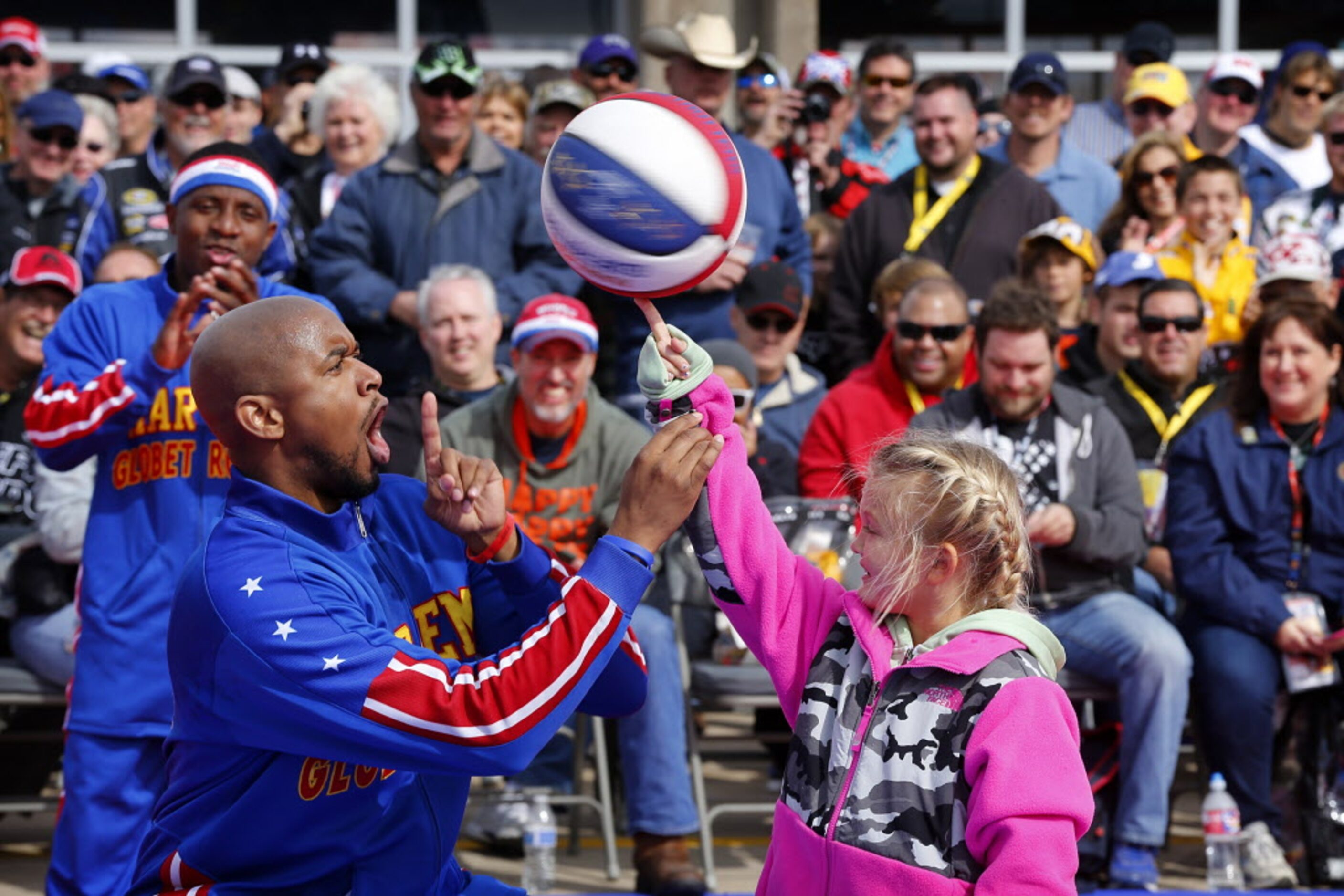 Darby Robinson, 8, of Wister, Oklahoma receives a little help spinning the ball on her...