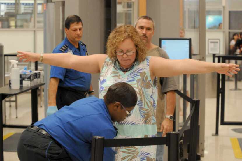 Airline passengers go through the Transportation Security Administration security checkpoint...
