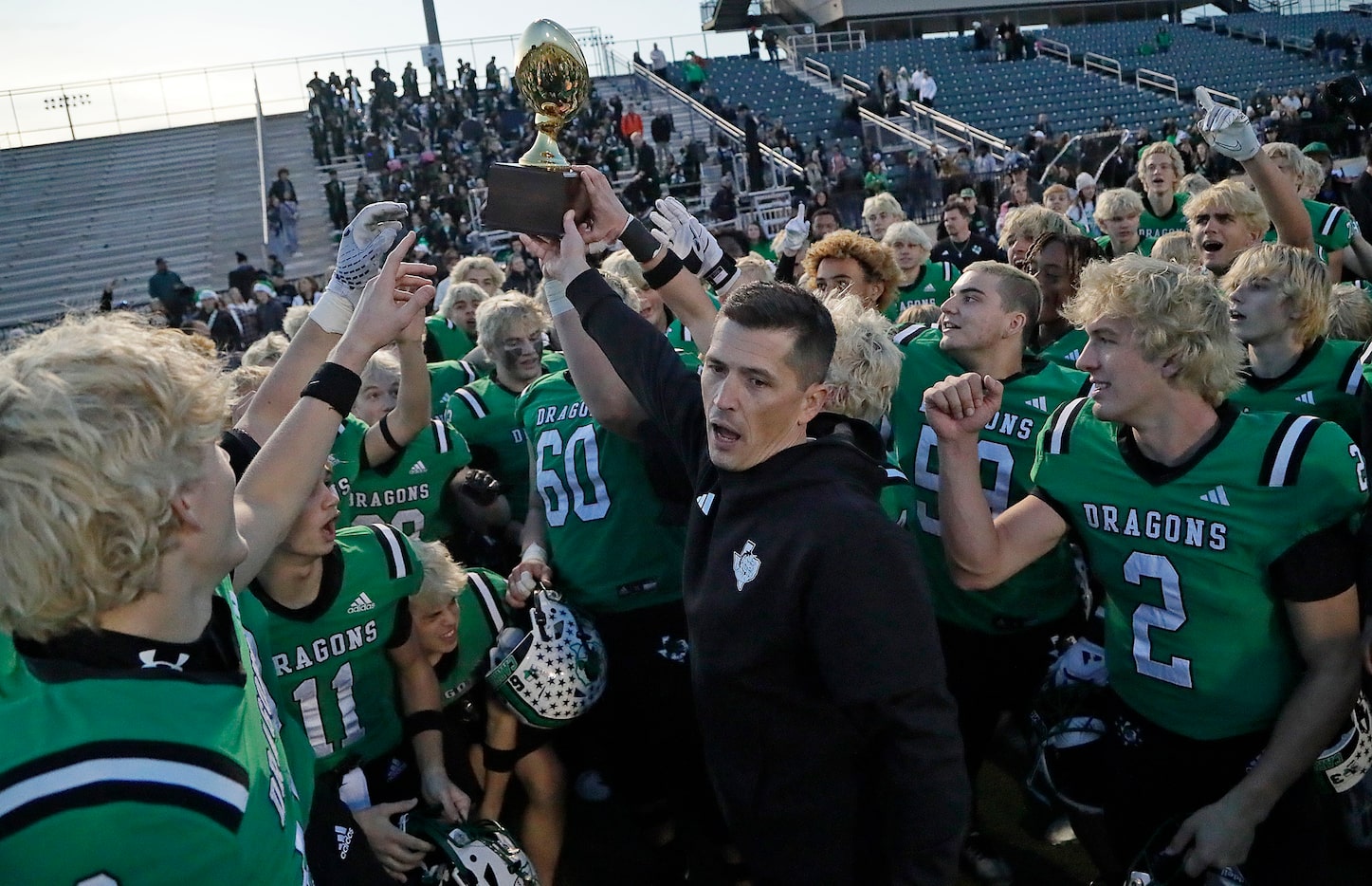 Southlake High School head coach Riley Dodge hoists the trophy after the win as Southlake...