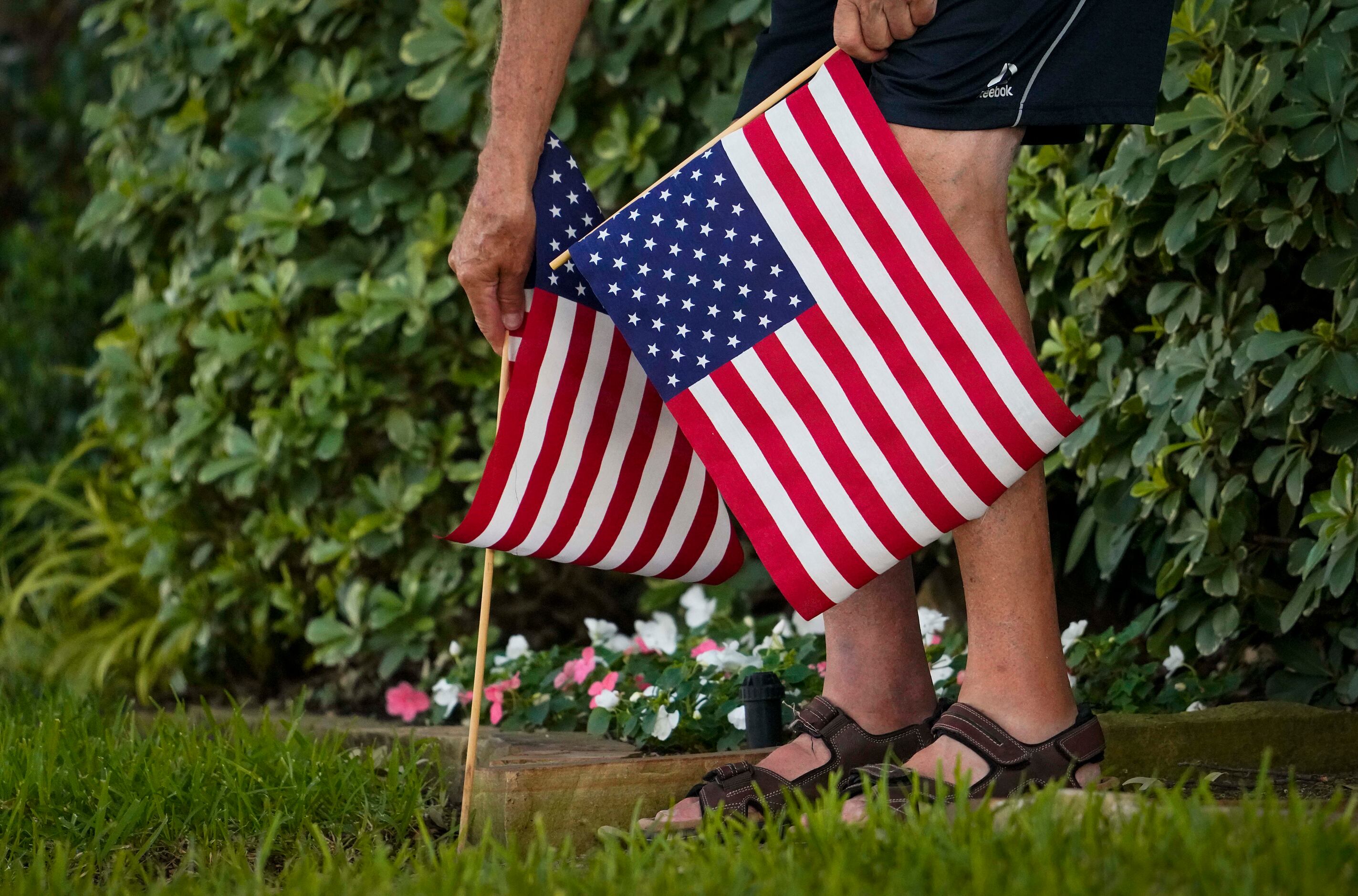 I resident places American flags in their yard in the Canyon Creek subdivision on Thursday,...