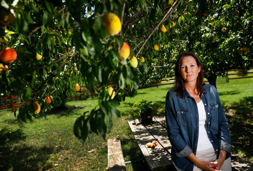 Argyle resident Gwende Wilmot poses for a photo in her small peach orchard behind her home....