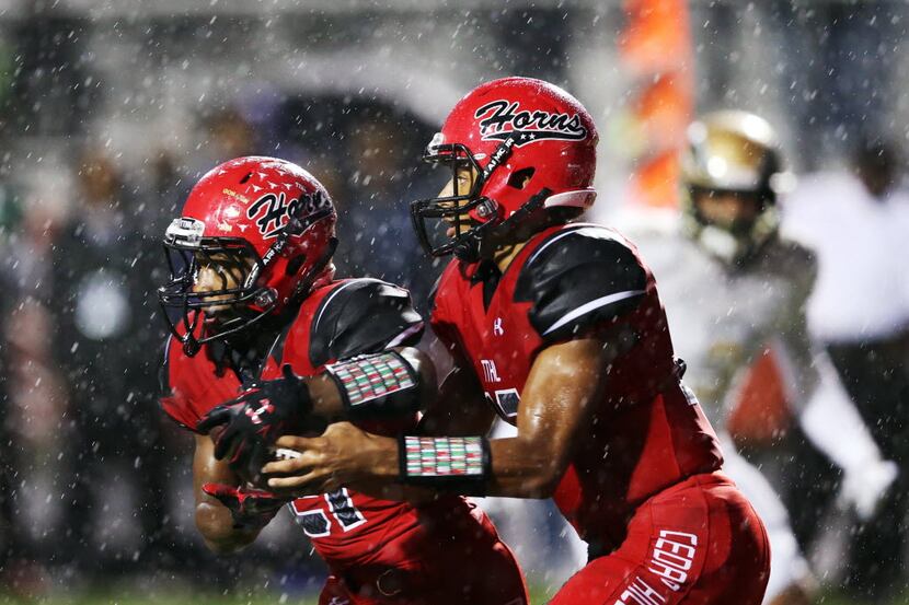 Cedar Hill's Avery Davis (12) fakes a handoff to Marquise Forman (21) in a game against...