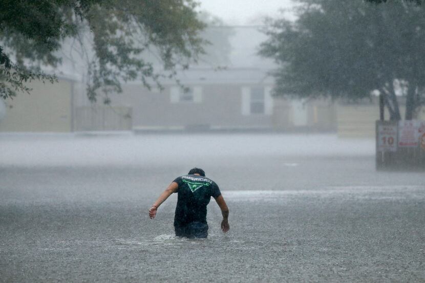 A man headed back into the flooded Pearland Acres Mobile Home Community in rural Pearland on...
