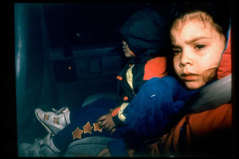 Two children being escorted from the compound. Twenty-one children left the compound during...