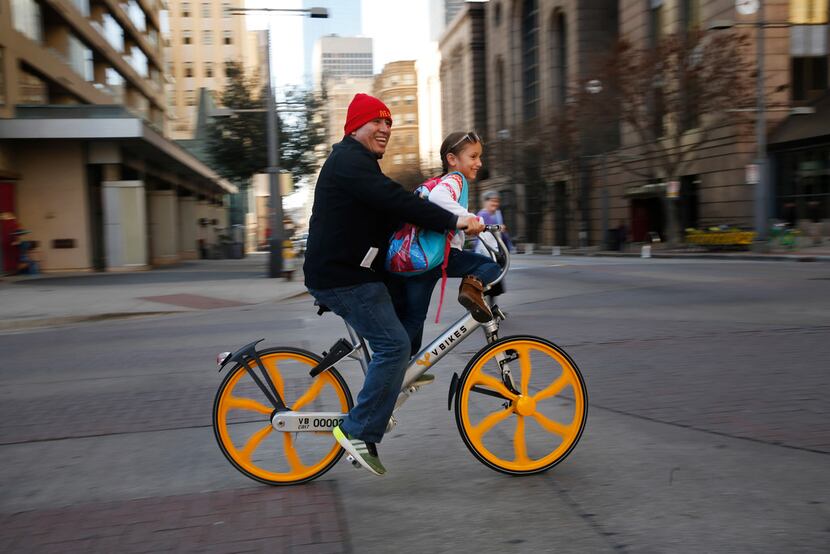 David Ramirez and his niece Giana Correa of Dallas rode a VBikes rental bicycle along the...