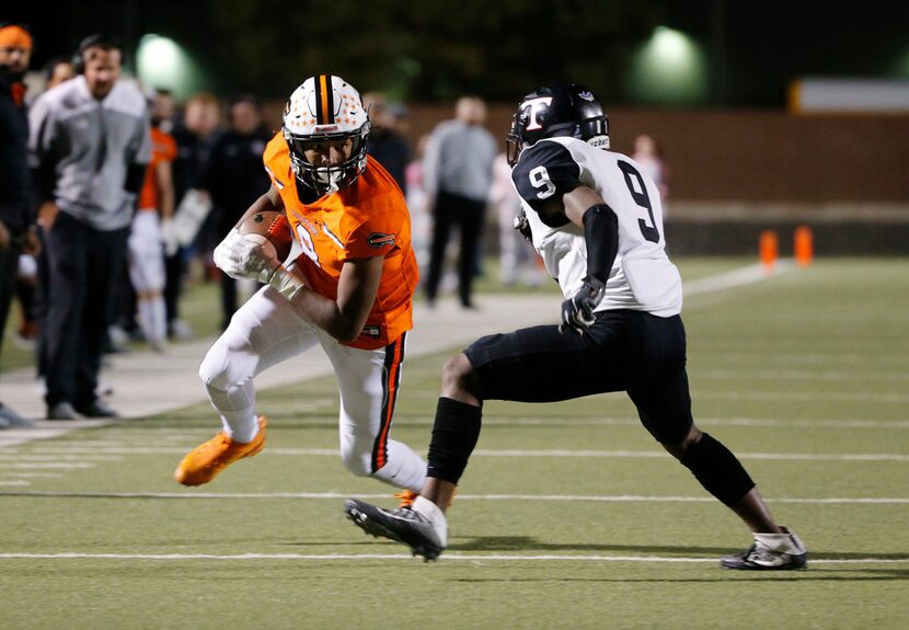 Haltom receiver Jace Washington catches a pass in front of Euless Trinity defender Camryn...