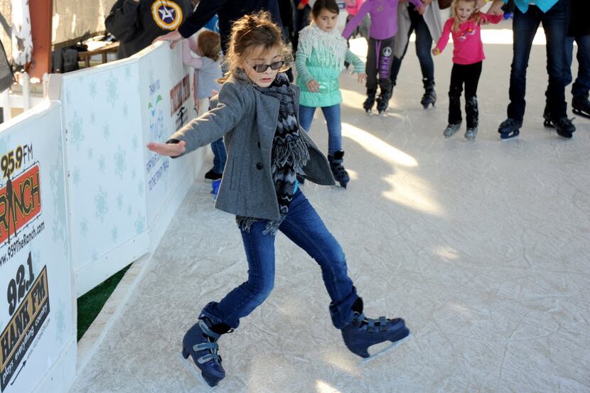 A skater attempts to keep her balance on the ice at Panther Island Ice at Coyote Drive-In in...