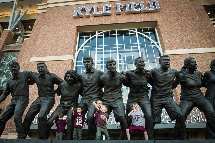 Texas A&M fans pose for photos at The War Hymn Monument before an NCAA football game against...