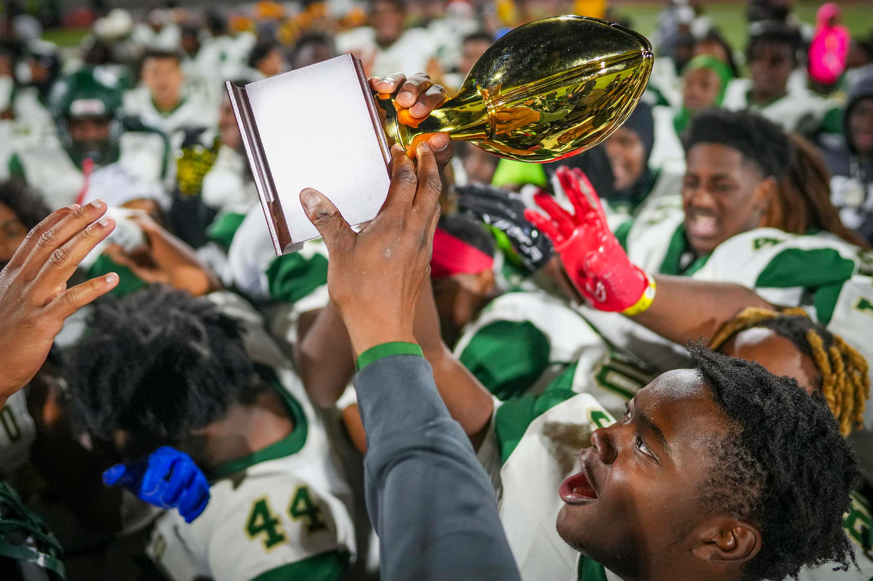 DeSoto players celebrate with the Class 6A Division II Region II championship trophy after a...