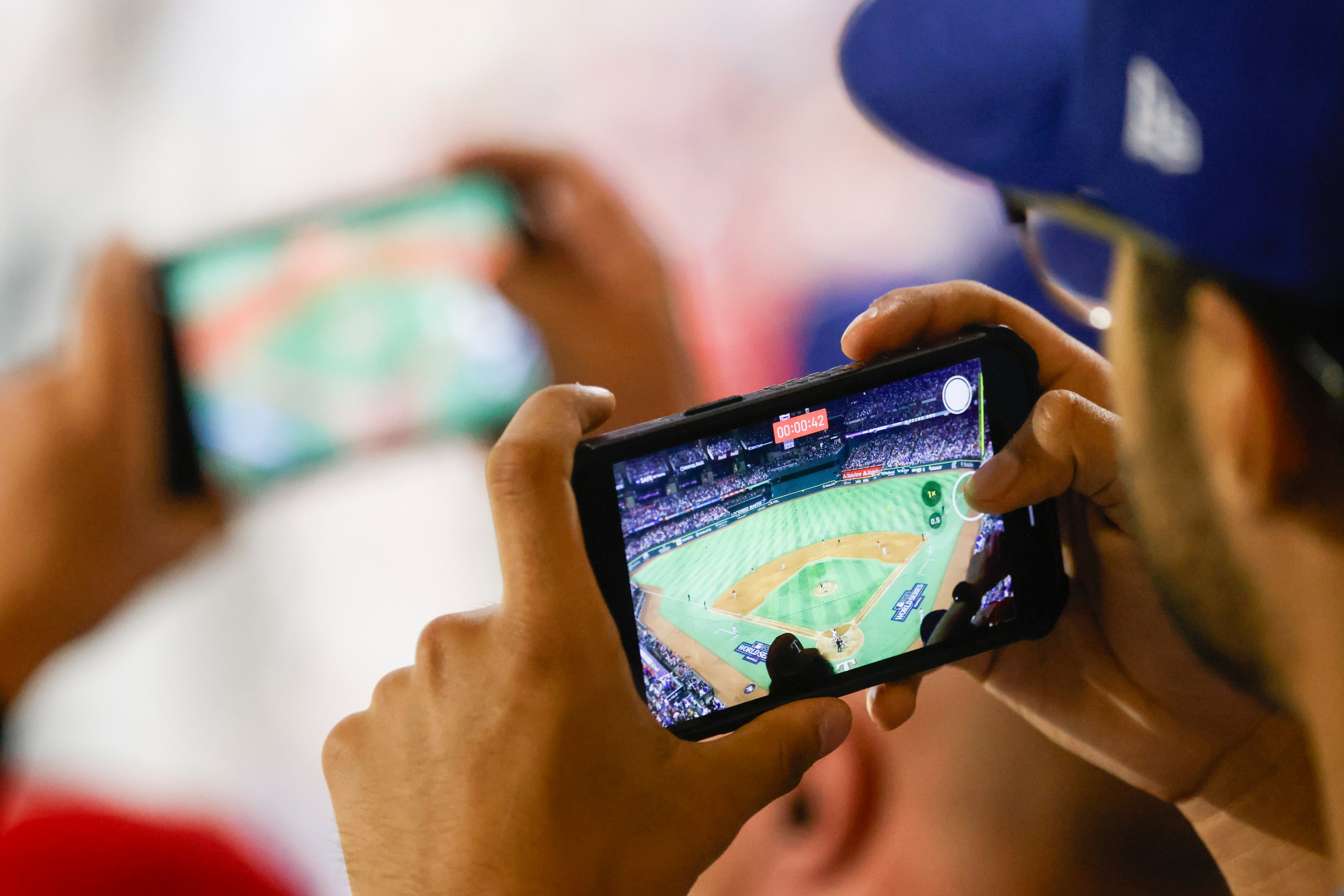 Fans record as Texas Rangers right fielder Adolis Garcia steps to the plate during the ninth...