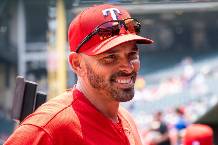 Texas Rangers manager Chris Woodward smiles in the dugout before a game against the Seattle...