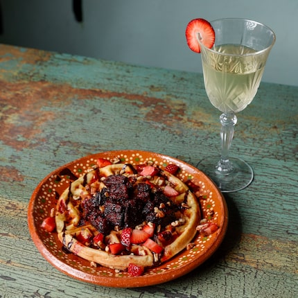 Raspberry-glazed burnt ends top a waffle at VBQ Smokehouse in Fort Worth. The restaurant is...