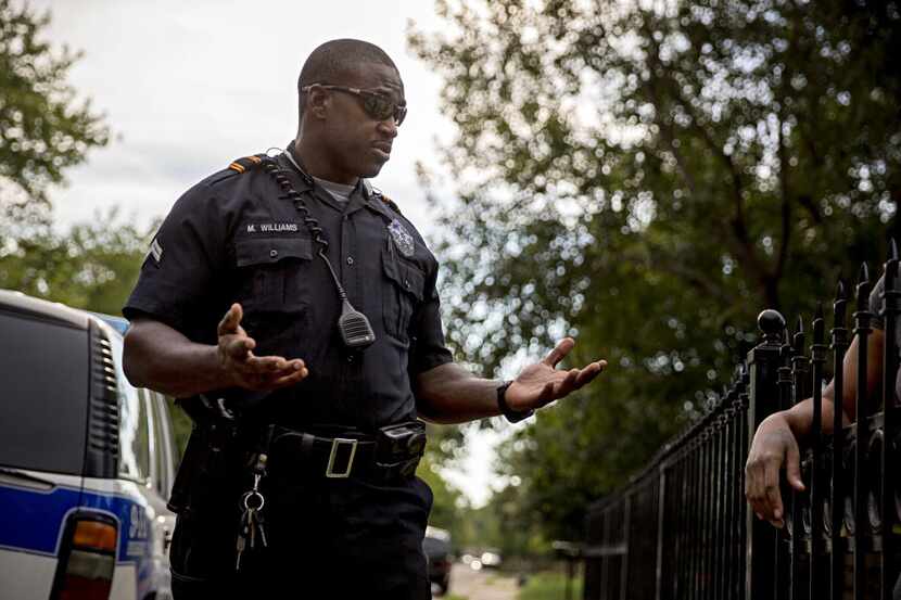 Dallas police Sr. Cpl. Melvin Williams talks with a woman in the Pleasant Grove area of...