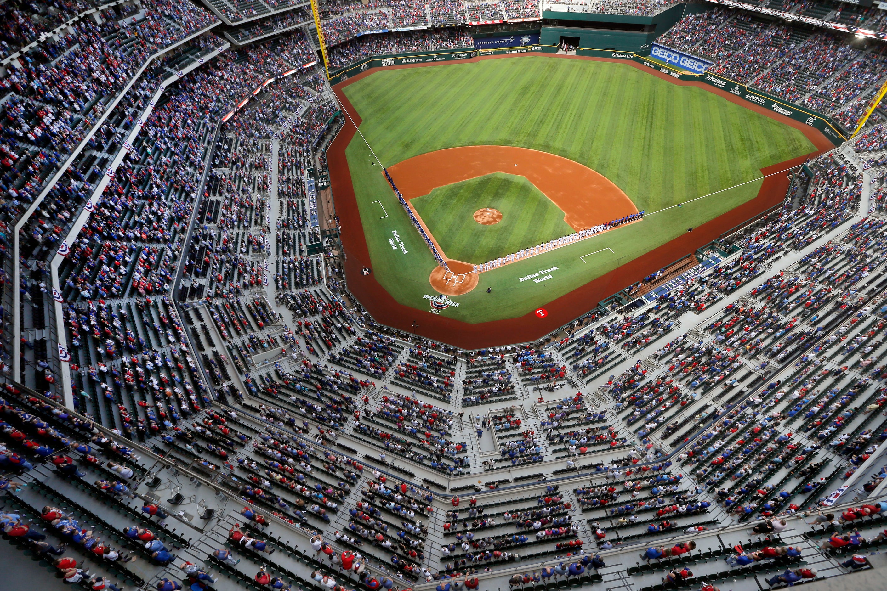 The Texas Rangers and Toronto Blue Jays baseball clubs line up on the base paths for the...