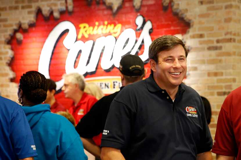 Raising Cane's Chicken Fingers founder Todd Graves (right) visits with employees at their...