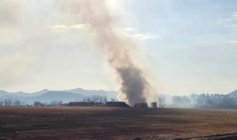 Los bomberos trabajan para extinguir un incendio en la pista de aterrizaje del Aeropuerto...