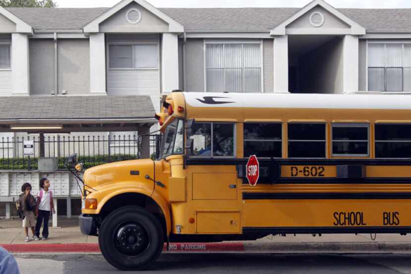 A school bus drops children off at the Amesbury Parc apartments, which may come down to make...