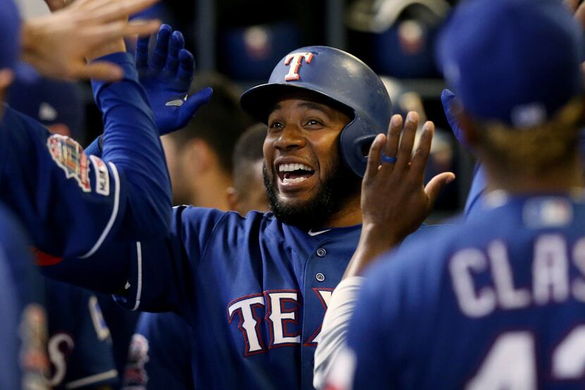 Elvis Andrus of the Texas Rangers celebrates with teammates after hitting a home run in the...