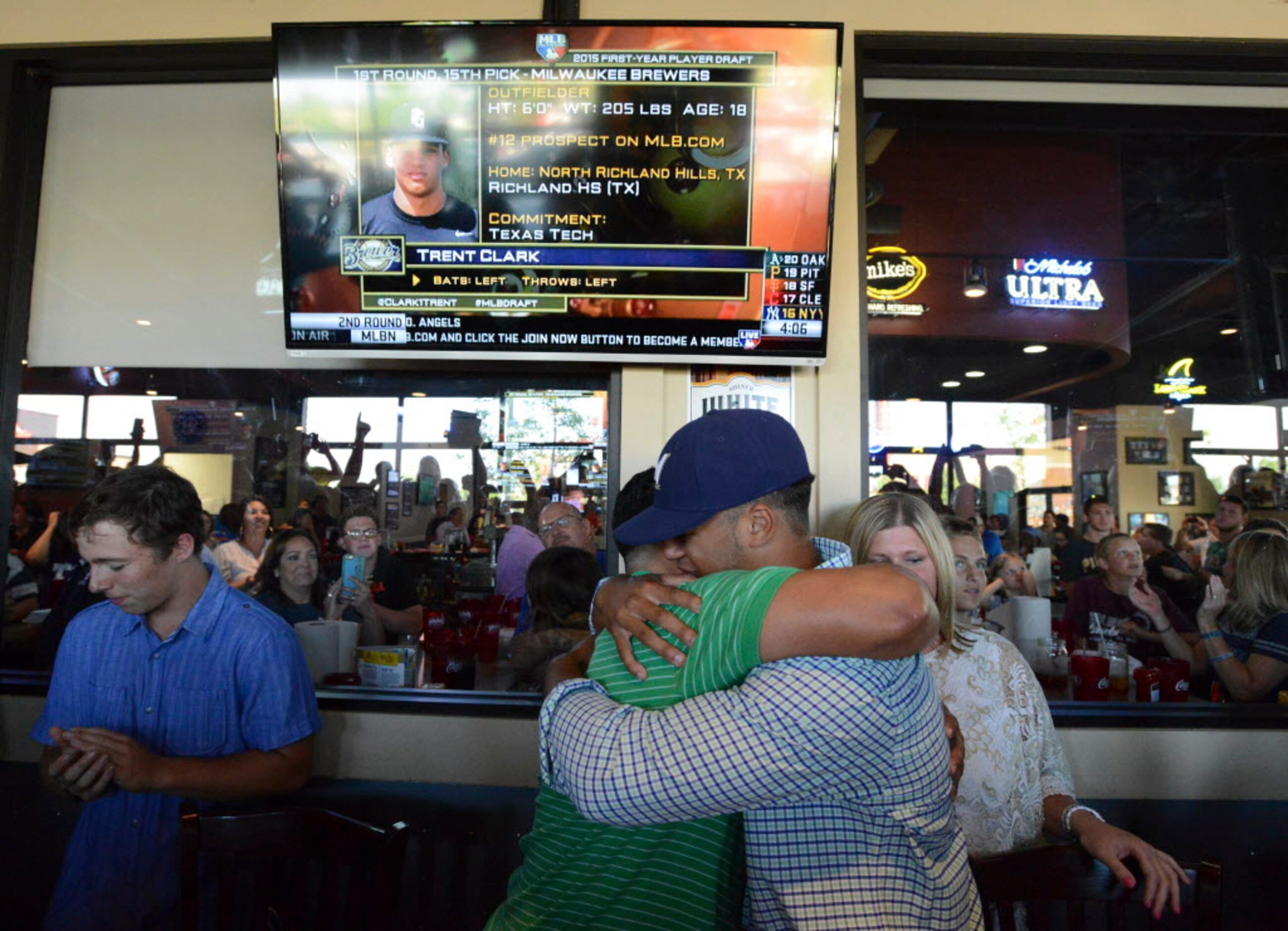 Trent Clark, right, gets a hug from John Guajardo after he was drafted by the Milwuakee...