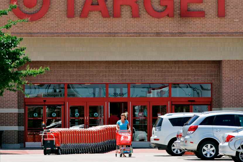 A shopper leaves a Target store with a shopping cart of items,  Thursday, June 12, 2008, in...