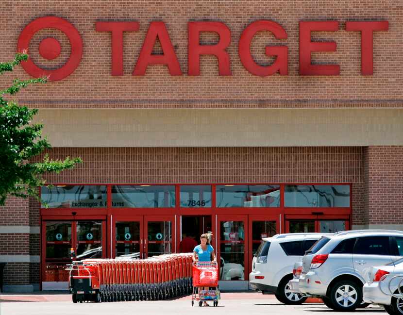 A shopper leaves an Irving Target store with a shopping cart full of items.