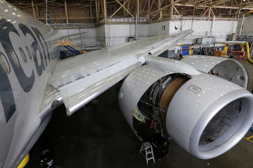 An American Airlines Boeing 777 jet undergoes maintenance inside a hangar at DFW...