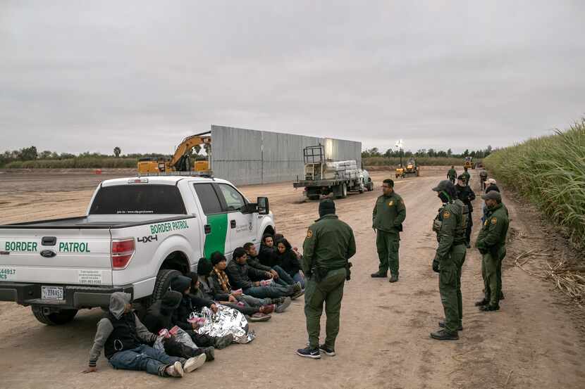 Border patrol agents with a group of immigrants along the Rio Grande border area.