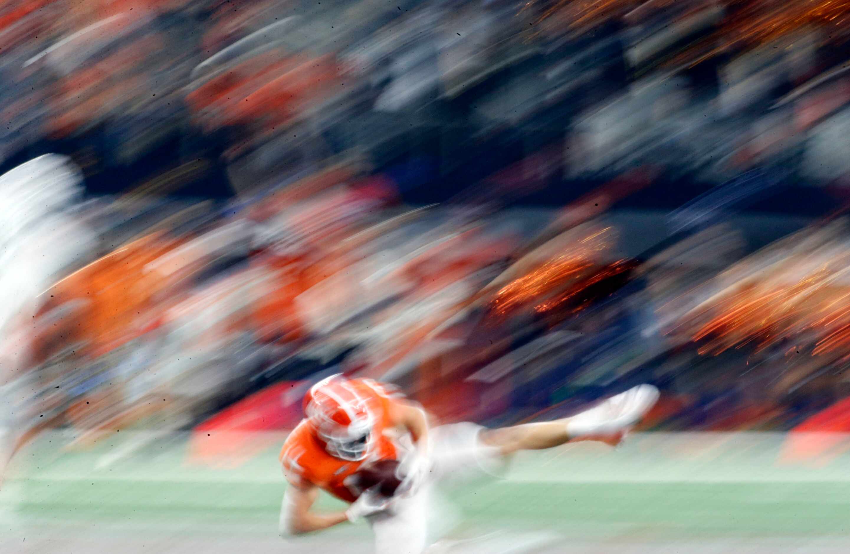 A Oklahoma State University receiver is a blur, as he makes a catch, during the second half...