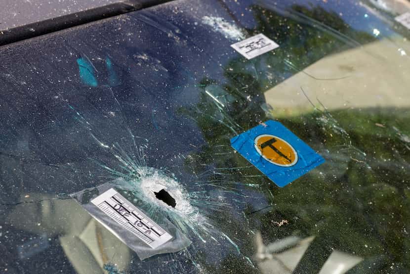 Bullet holes are visible in the windshield of a sedan after a shooting occurred near the...